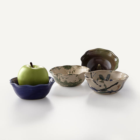4 pottery apple bakers, like small bowls, in various colors. One has an apple.
